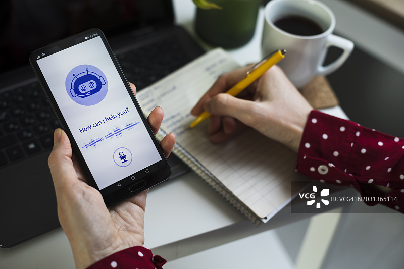 年轻商人使用AI聊天机器人在电脑或移动应用程序中进行交流图片素材