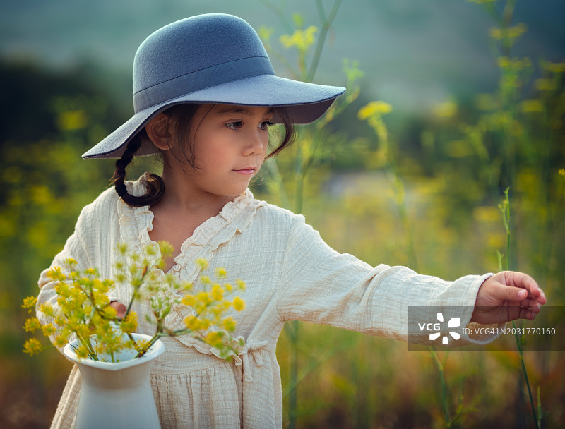 小女孩在开满野花的草地上图片素材