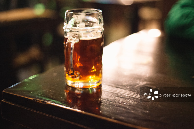 酒吧木桌上的啤酒杯图片素材