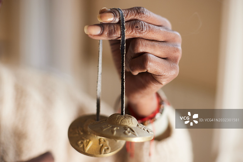 正念冥想：带有藏族钹冥想铃的女性手部特写图片素材