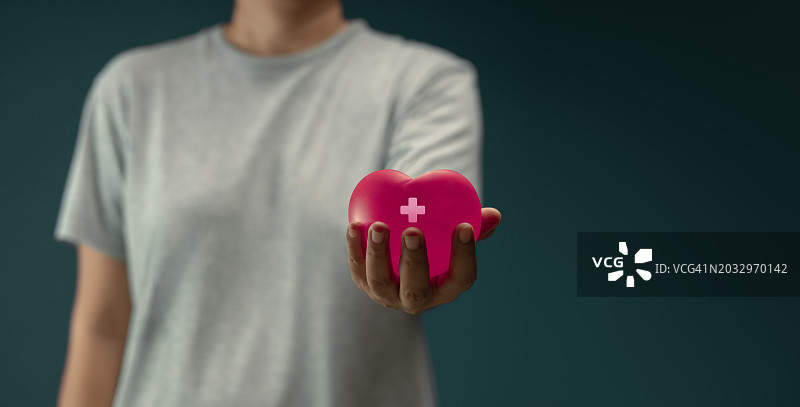 男子在泰国灰色背景下手持心形的腰部特写图片素材