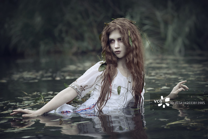 池塘里藻类旁的苍白女孩Mavka肖像图片素材
