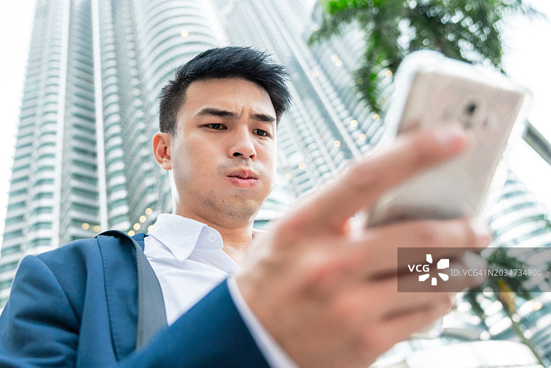 用智能手机阅读坏消息的中国商人图片素材