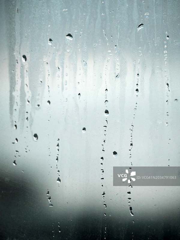 聚焦：英国伦敦雾气蒙蒙的窗户上的雨滴，阳光和自然色彩图片素材