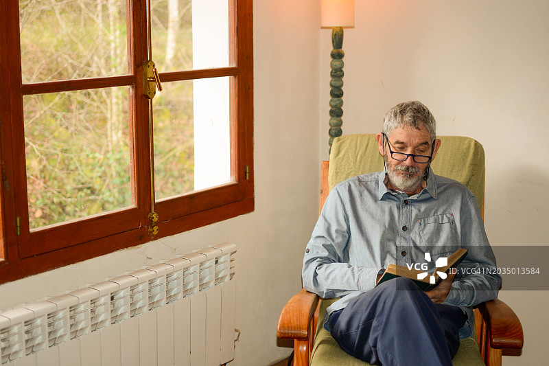 一位60岁的老人在家安静地阅读图片素材