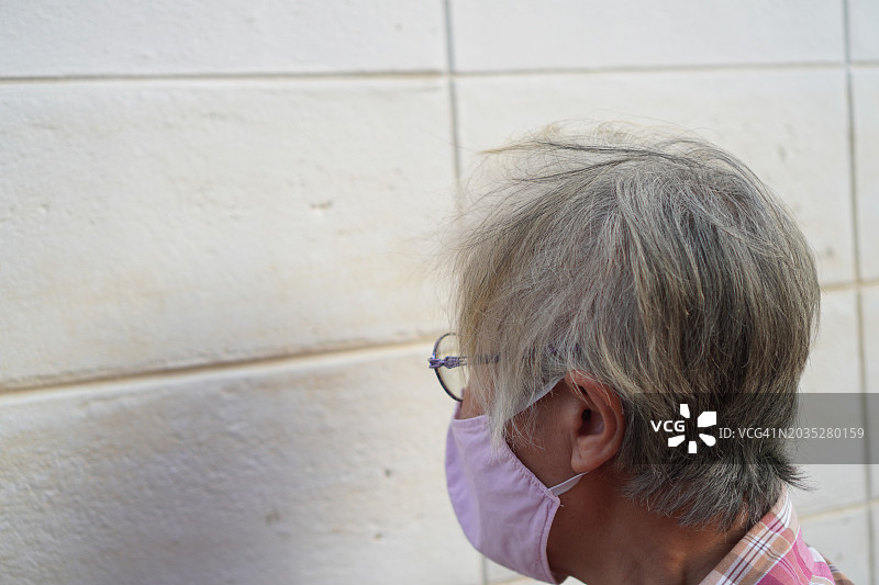 老妇人看着墙壁图片素材