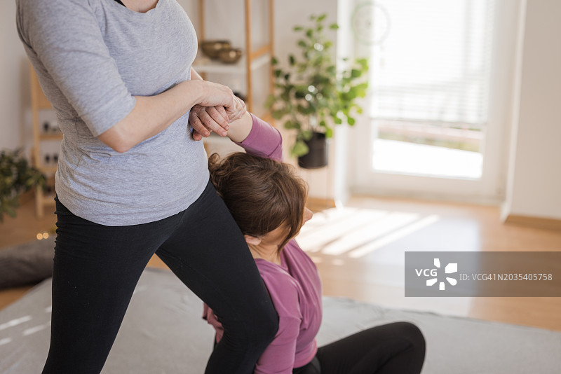 理疗师使用泰式按摩为女性缓解疼痛图片素材