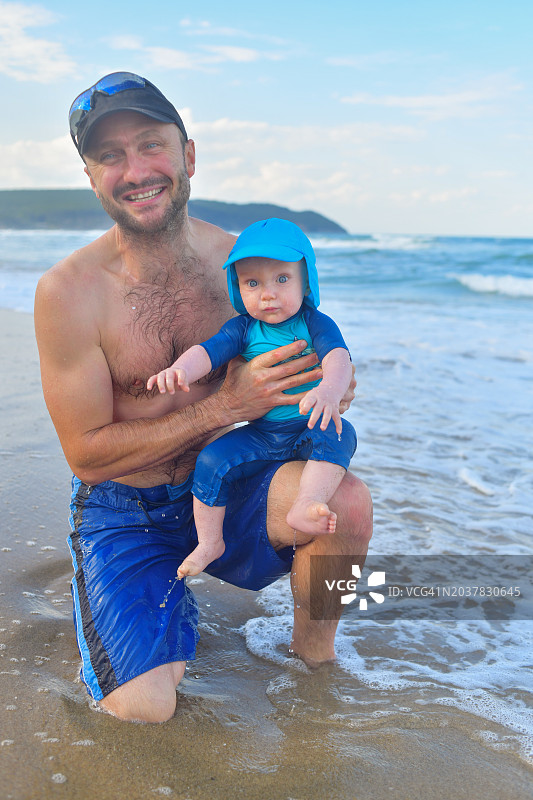 海滩上有魅力的男人和男婴图片素材