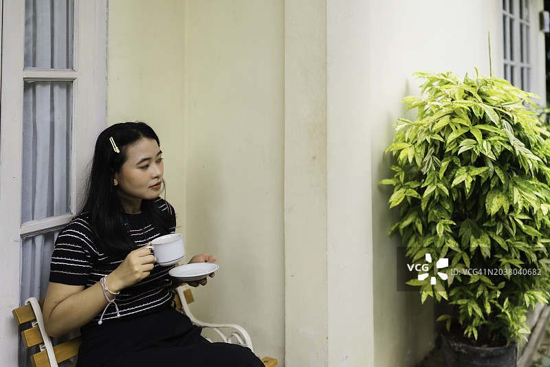 在露台上喝咖啡的女人图片素材