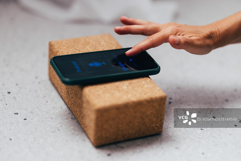 手在软木支架上操作智能手机特写图片素材