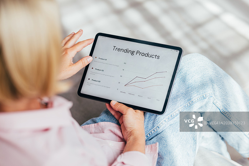 职场女性用平板电脑分析热门产品图表图片素材