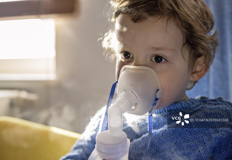 幼儿园年龄的小男孩因呼吸道疾病使用吸入器图片素材