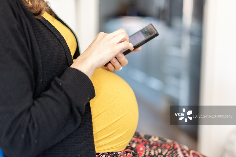 使用智能手机的孕妇图片素材