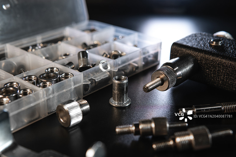 螺纹插入铆钉枪套件，适用于所有类型铆钉的安装工具、鼻件和插件，包括螺纹铆钉螺母、钳子，黑色背景，选择性聚焦图片素材