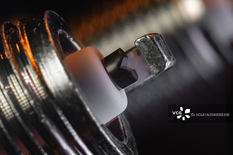 汽车汽油发动机火花塞特写，镍电极，绝缘体。汽车服务、维修概念，黑色背景图片素材