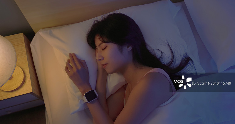 亚洲女性戴着智能手表睡觉图片素材