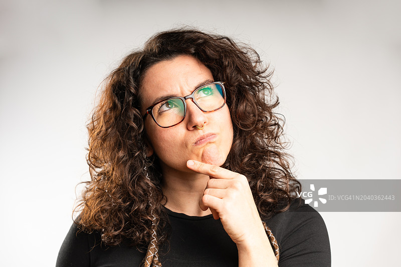 沉思的女人手托下巴向上看图片素材