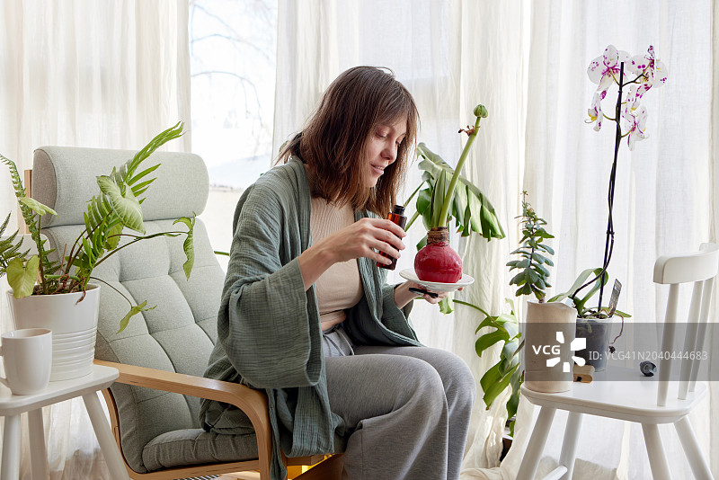 居家浴袍女子浇花图片素材