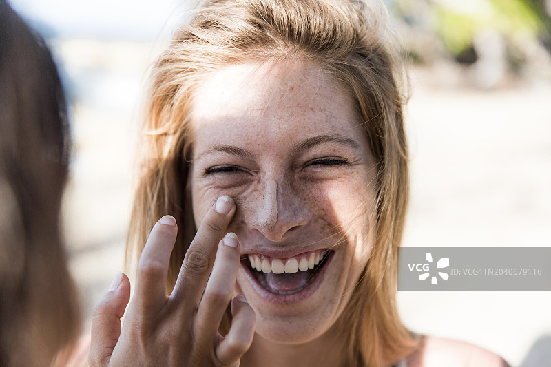 年轻女子涂抹防晒霜的肖像图片素材