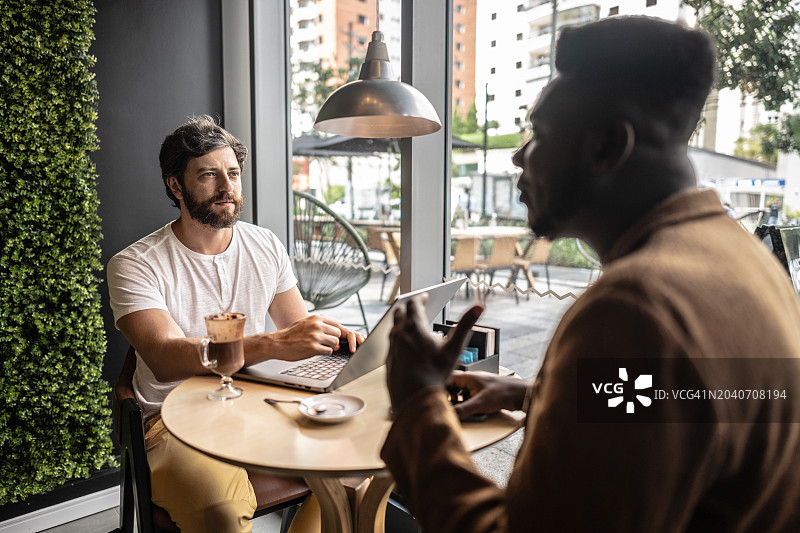 同事们在咖啡店的商务会议上交谈图片素材