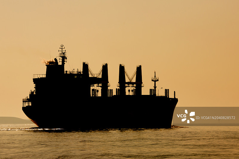 日落时分大型货船的轮廓图片素材