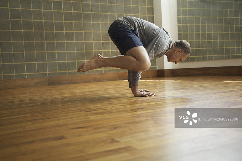 年长的男人练习瑜伽，乌鸦式图片素材