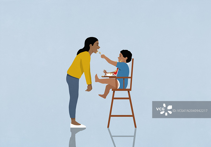 可爱的男婴哥哥在高脚椅上喂妹妹图片素材