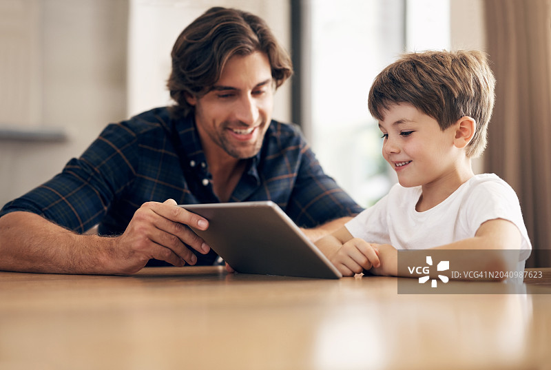 父亲教孩子使用平板电脑玩游戏图片素材