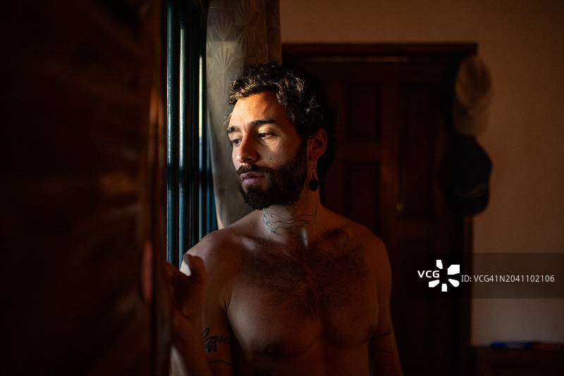 男人站在窗边图片素材