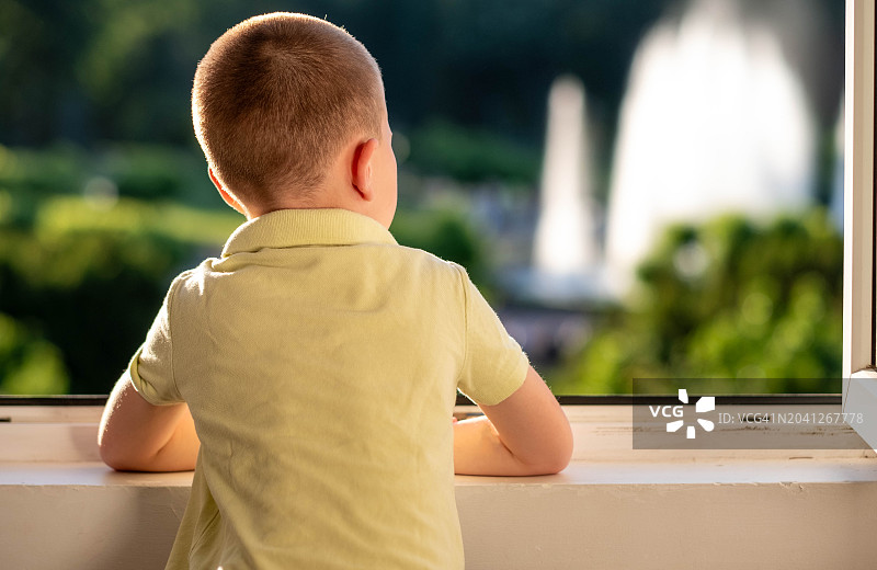 男孩正在向窗外看图片素材