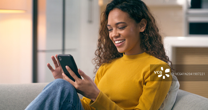 居家女人微笑玩手机，连接社交媒体图片素材