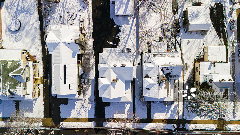 一排排被雪覆盖的房屋，沿着新泽西州麦迪逊的住宅区延伸图片素材