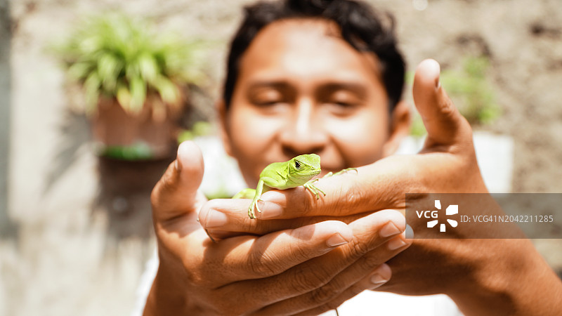 手持小鬣蜥的男人图片素材