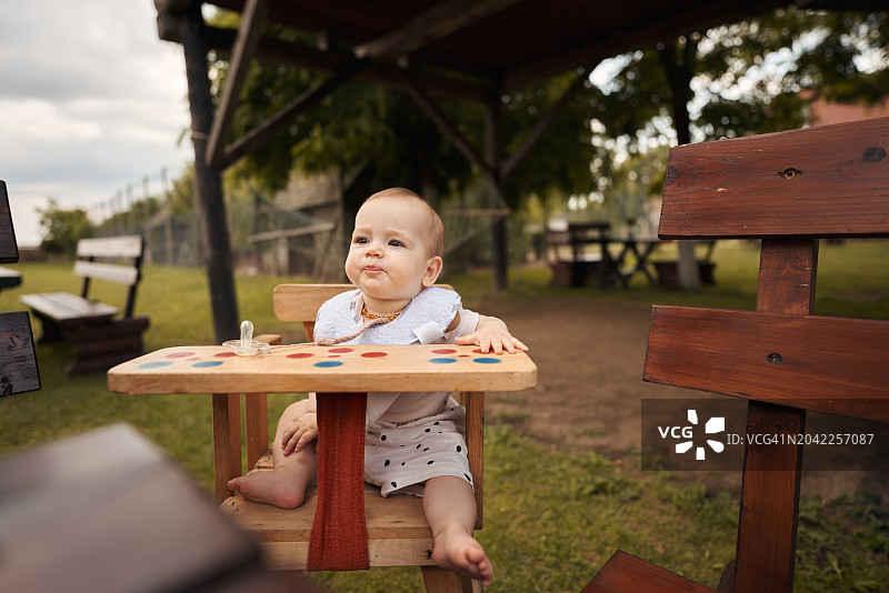 可爱的女婴在公园的椅子上放松图片素材