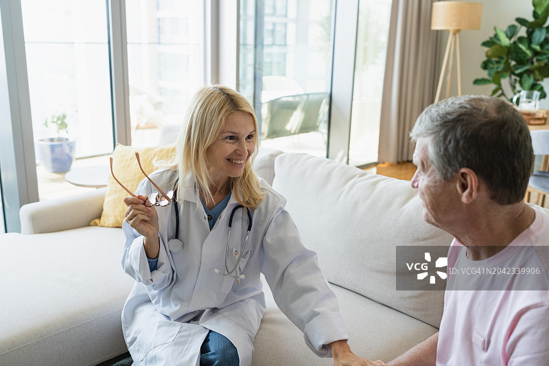 女医生在家中与老年患者交谈并安慰图片素材