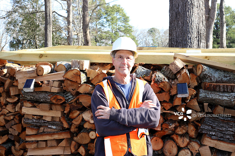 为树艺师工作的男人站在他的木堆前图片素材