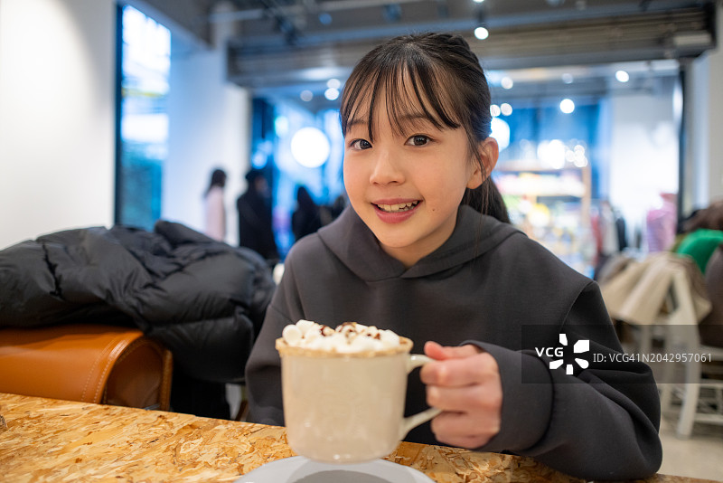 在咖啡馆里拿着咖啡杯的少女图片素材