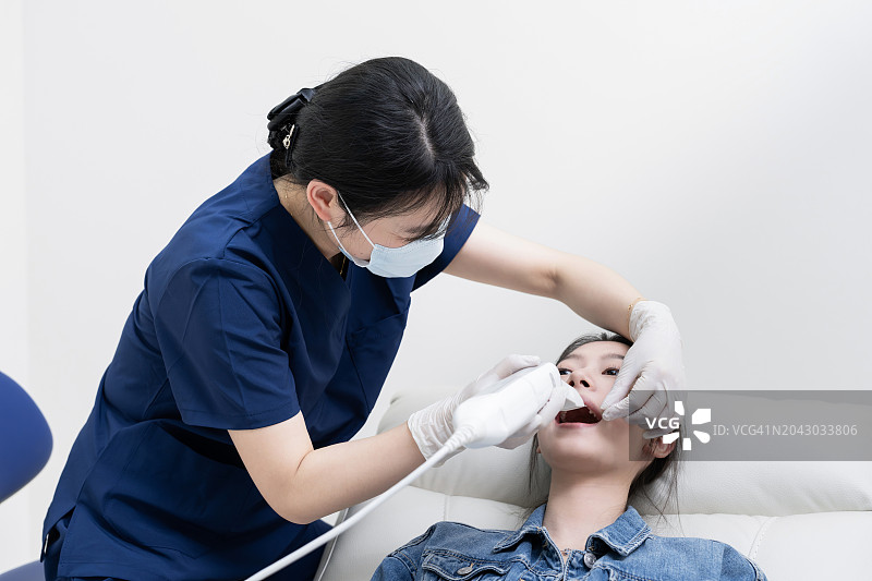 年轻的亚洲女性在牙医诊所检查牙齿图片素材