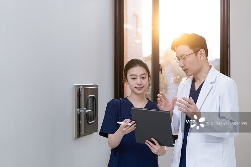 医生和护士在诊所走廊讨论图片素材
