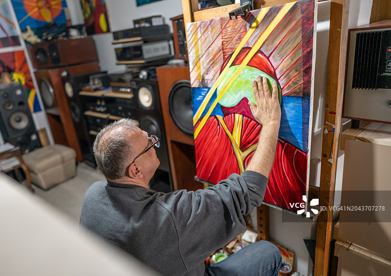 年长的艺术家在他的画布上绘画图片素材