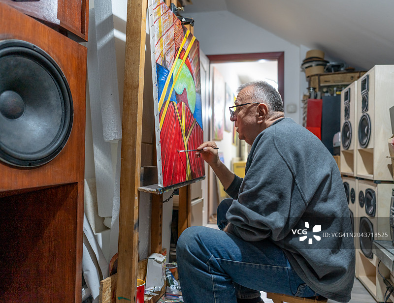 年长的艺术家在他的画布上绘画图片素材