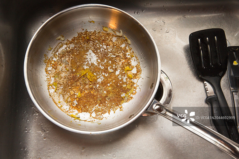 油腻的煎锅、水槽里的脏盘子图片素材