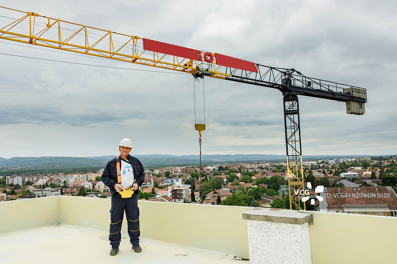 微笑的中年起重机操作员在露台上工作图片素材