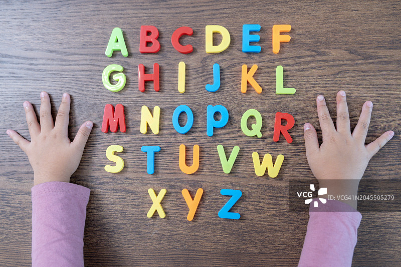 女孩在玩英语字母。图片素材