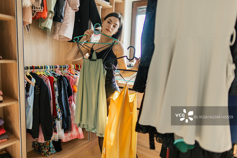 在家试穿连衣裙的年轻女人图片素材