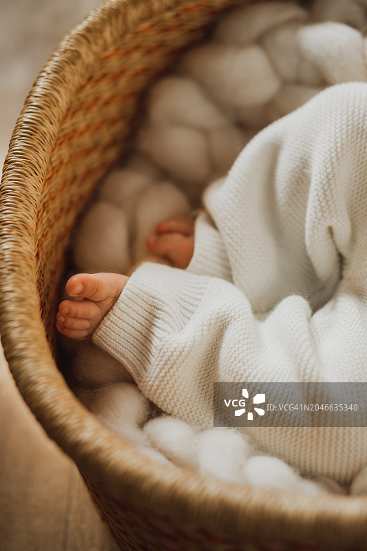 在家中婴儿床里睡觉的男婴的腿部图片素材