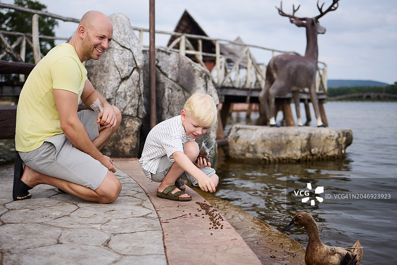 父亲和儿子在泰国度假时参观有鹿的自然公园图片素材