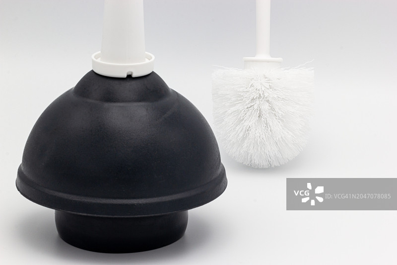 白色背景上的黑色马桶搋子和白色马桶刷图片素材