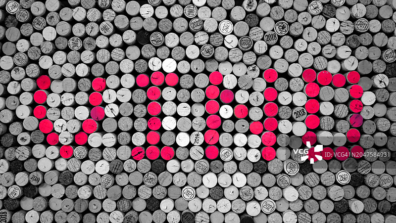 用红漆和黑白色软木塞写成的单词“VINO”图片素材