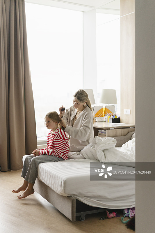 母亲在家中为女儿扎头发图片素材